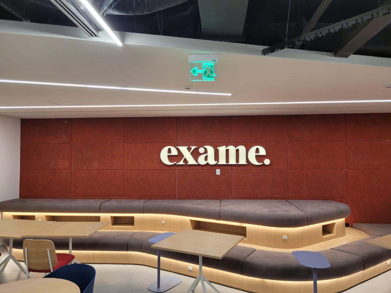 Ambiente corporativo finalizado com marcenaria, iluminação e revestimentos