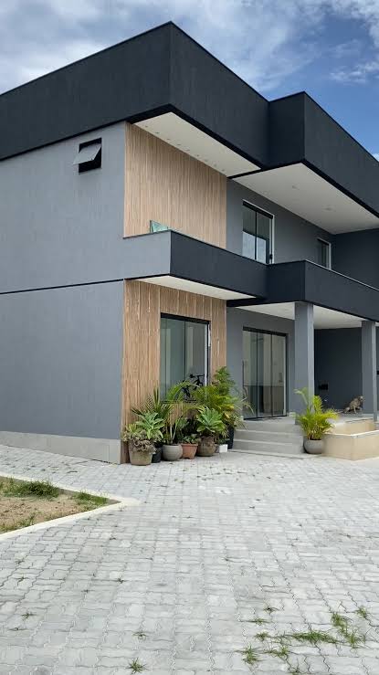 Fachada residencial contemporânea finalizada em tons de cinza e madeira